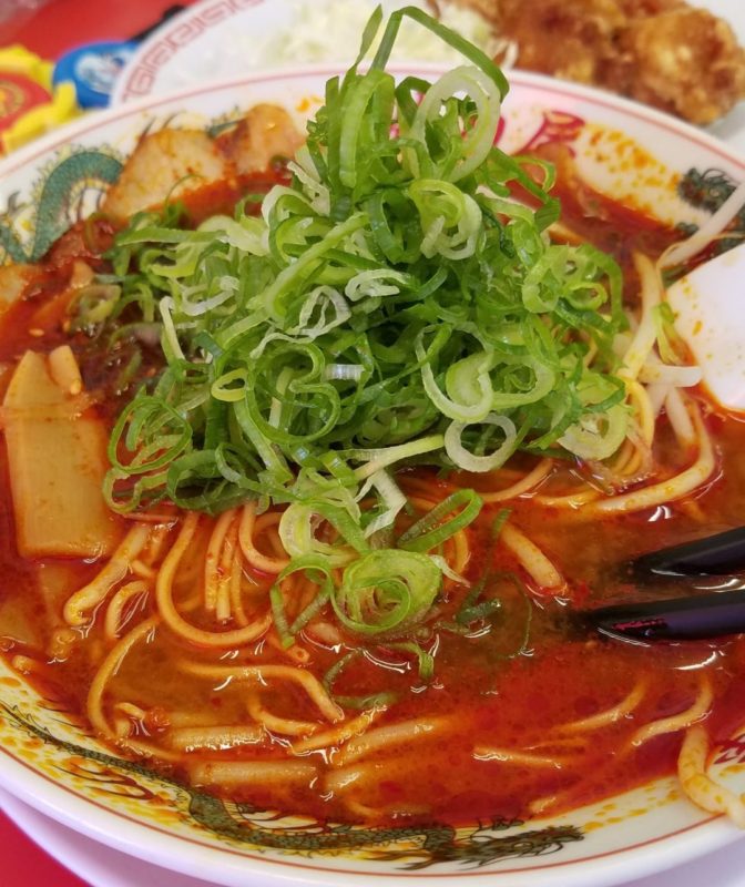 辛みそラーメンの上にネギが乗っていますが、各テーブルにネギとたくあんが用意されているため、好き勝手に増すことができます。